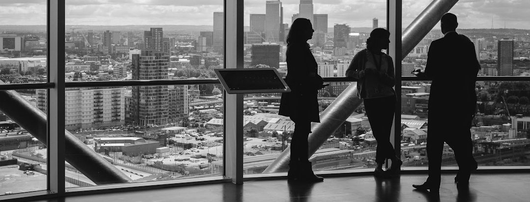 SourceArc Advisory leaders perspective on semiconductor supply chains SourceArc Advisory leaders discussing resilient semiconductor supply chain consulting, city skyline in background.